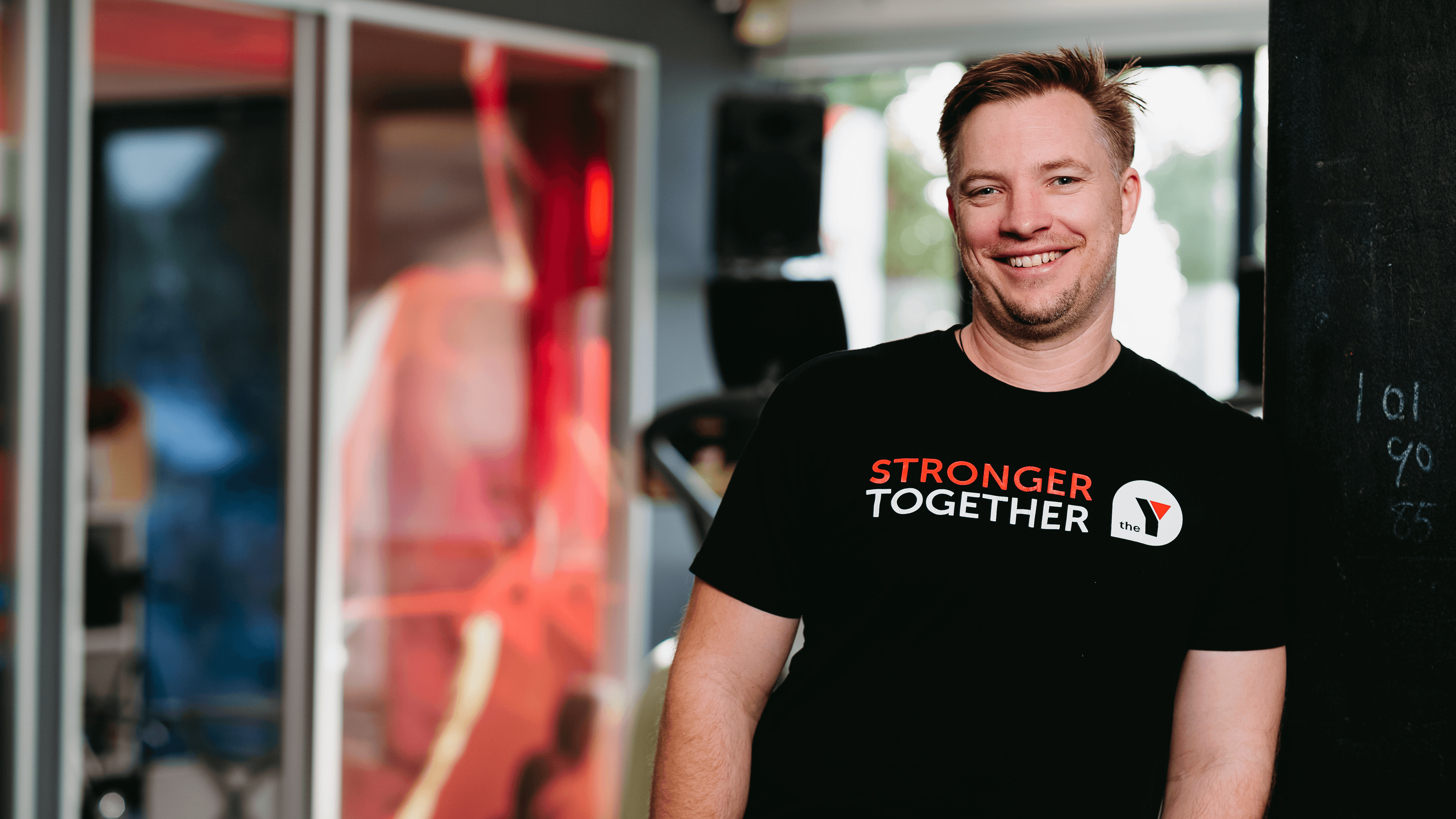 YMCA Auckland employee smiling at the camera in uniform.