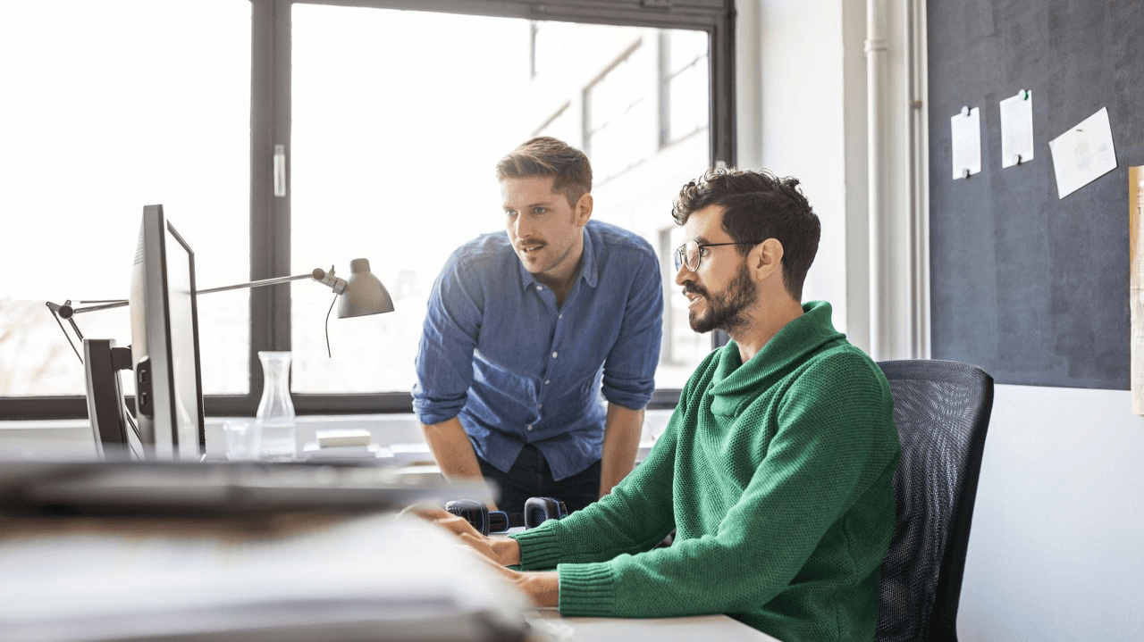 Office workers sitting at a computer.