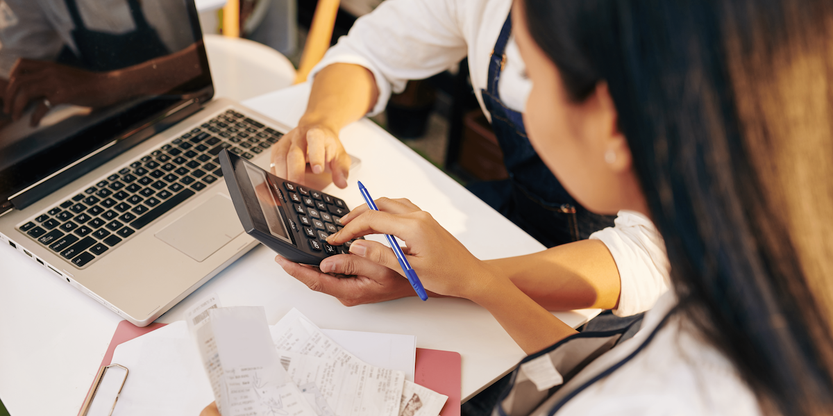 Two workers doing manual payroll entries. 