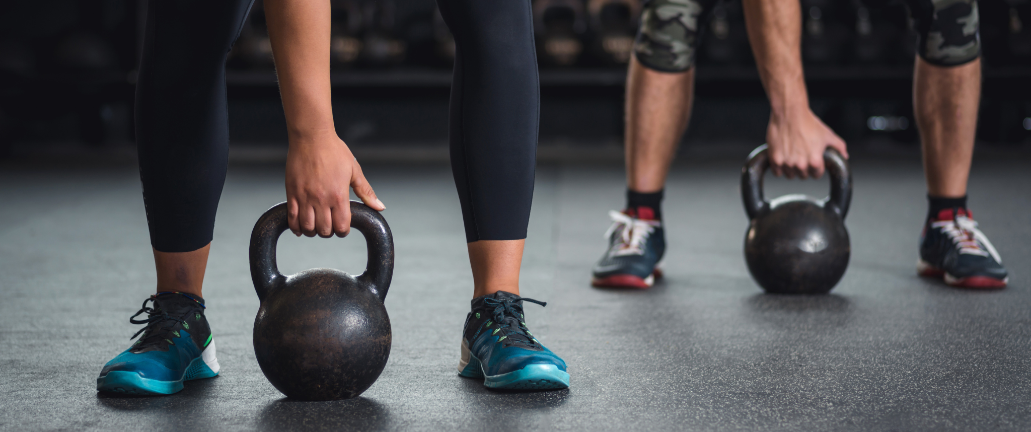 People at gym using kettlebells