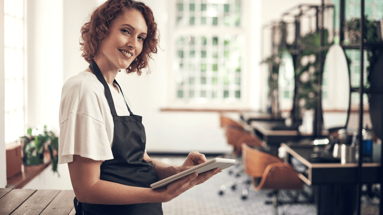 Woman smiling and working on a tablet.