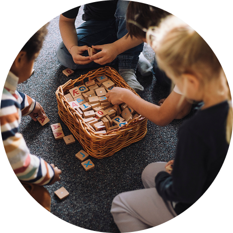 Three preschool children play with blocks.