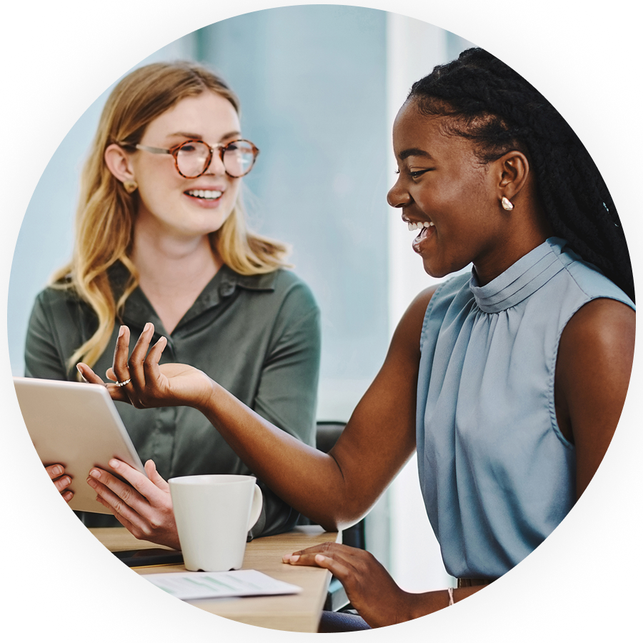 Two women smiling in a business meeting in an office environment