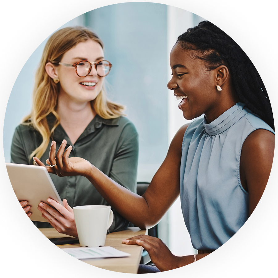 Two women smiling in a business meeting in an office environment