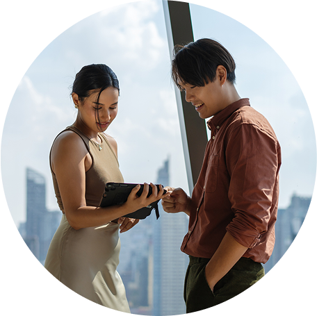 A couple on a balcony makes a payment on a tablet.